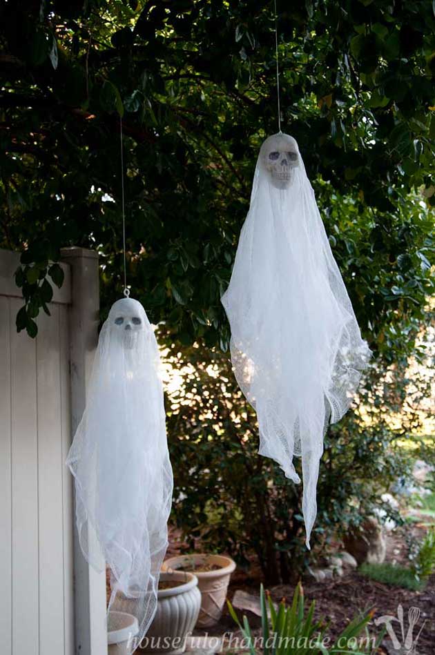 Hang skull ghosts from your front porch to spooky up your Halloween visitors.