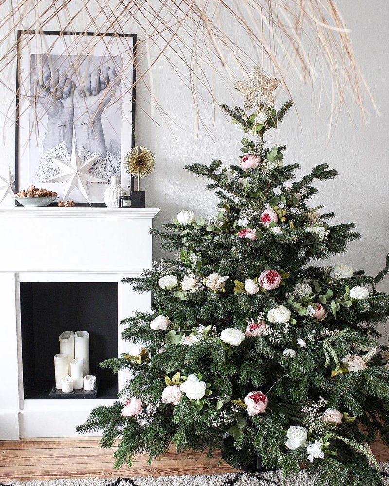 A beautiful, decorated Christmas tree with flowers fir.