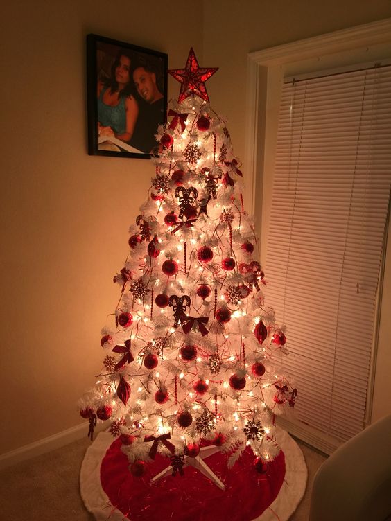 Amazing beautiful white Christmas tree with red ornaments.