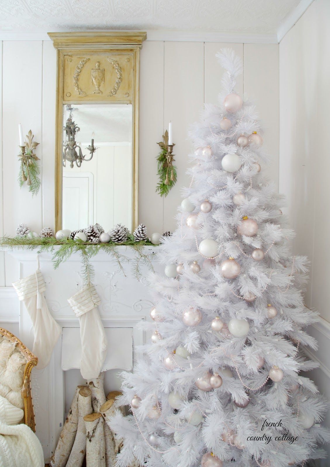 White Christmas tree with light and pastel-colored ornaments.